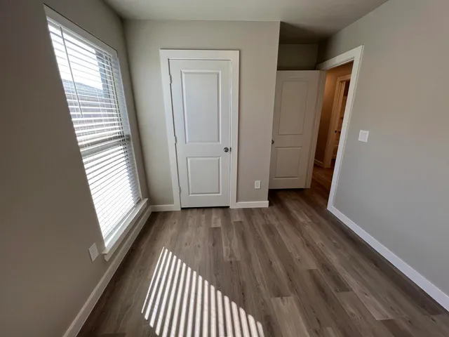 a view of a room with wooden floor and windows