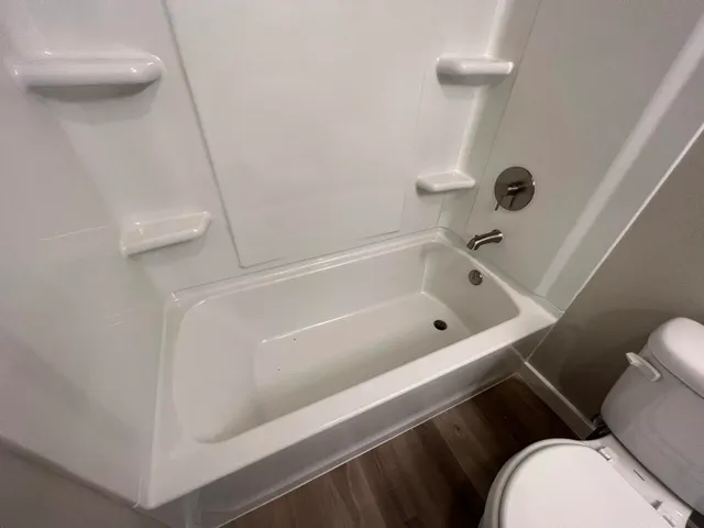 a white bath tub sitting next to a toilet