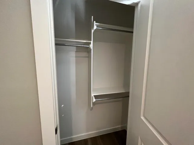 a view of walk in closet with empty racks