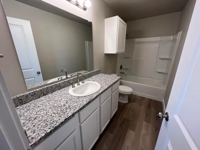 a bathroom with a granite countertop sink and a mirror