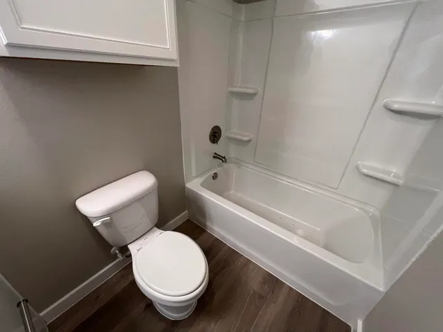 a white toilet sitting next to a bathtub