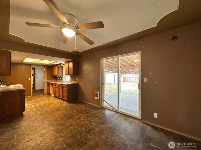 a view of a room with cabinet a flat screen tv and kitchen view