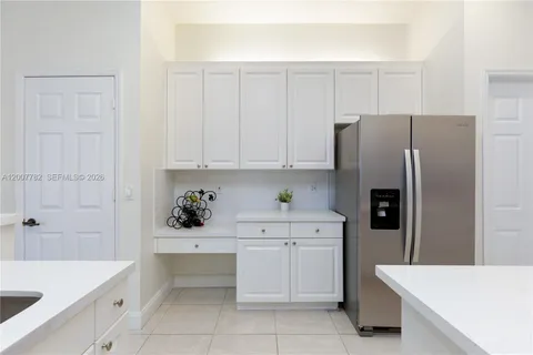 a kitchen with white cabinets and refrigerator
