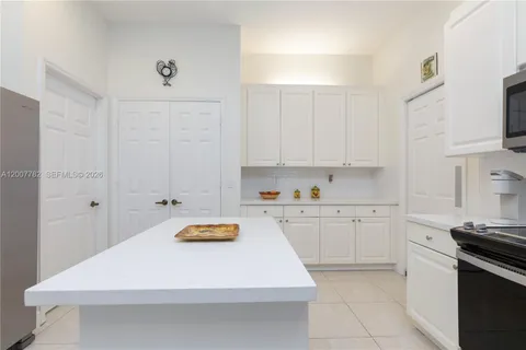 a kitchen with white cabinets appliances and sink