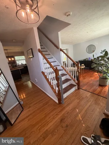 a view of a hallway with wooden floor and stairs