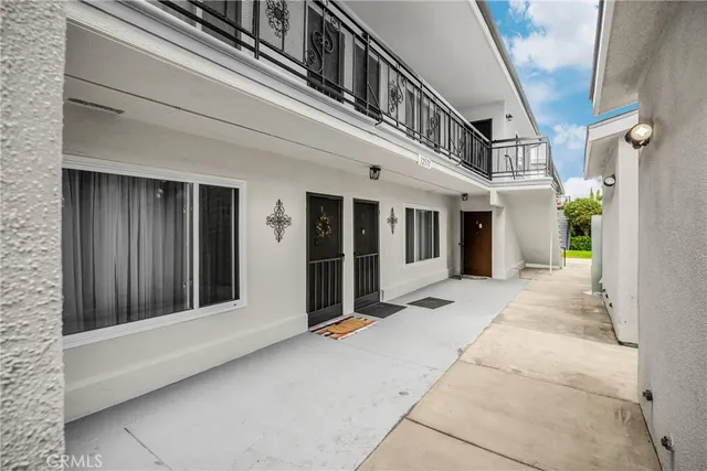 a white house that has tree in front of it