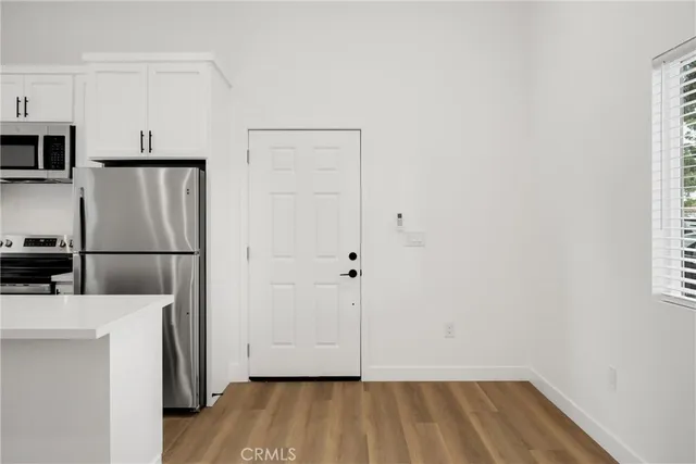 a view of a kitchen with wooden floor and electronic appliances