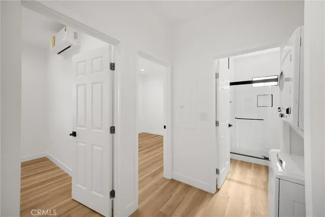a view of a hallway with wooden floor and white walls