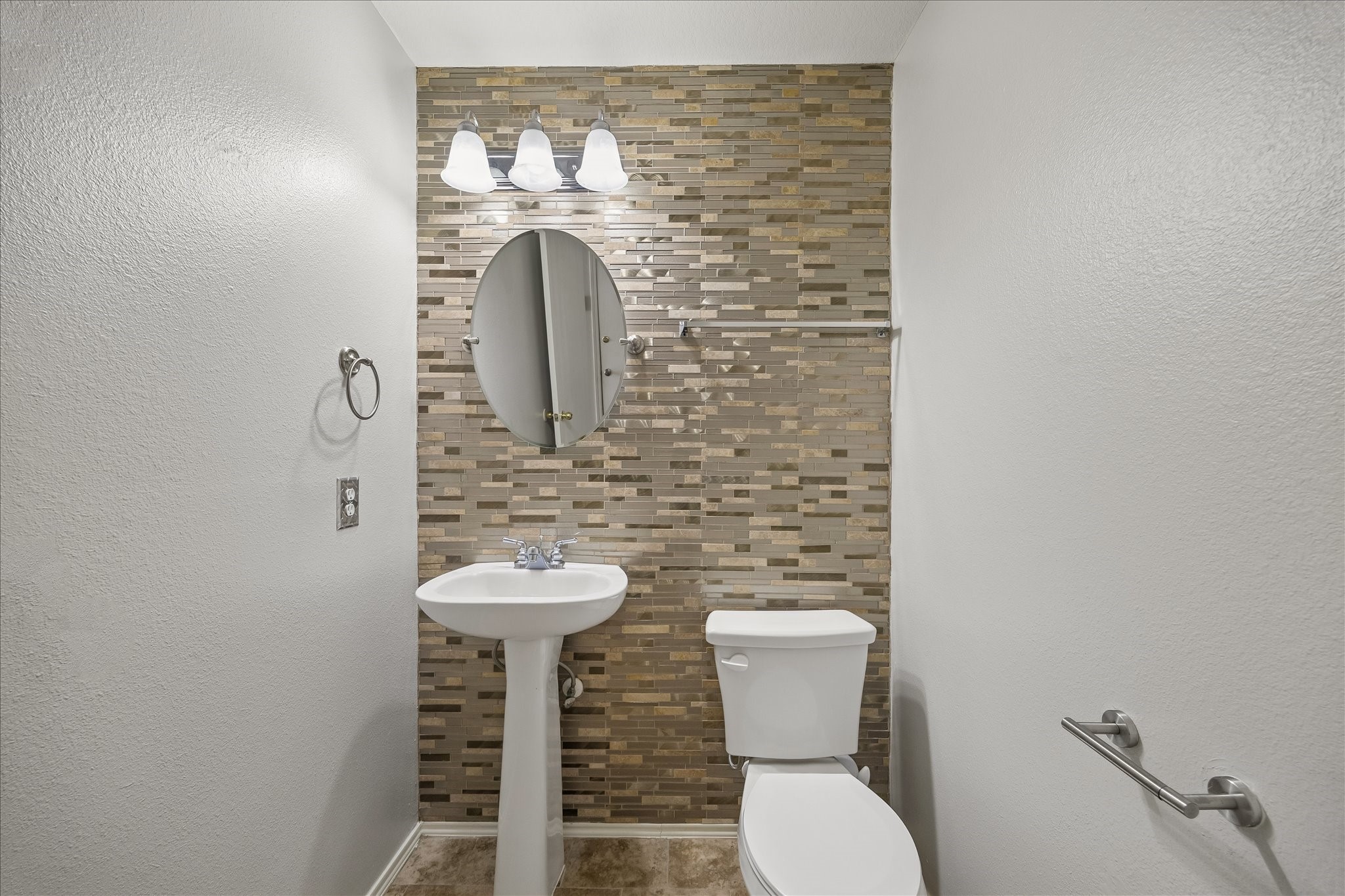 223 Sunset Colony Drive Rosharon, TX 77583 - Photo 15 of 50 This downstairs powder bath keeps daily living convenient with a stylish accent wall, pedestal sink, sleek mirror, updated vanity lighting and a clean, streamlined look.