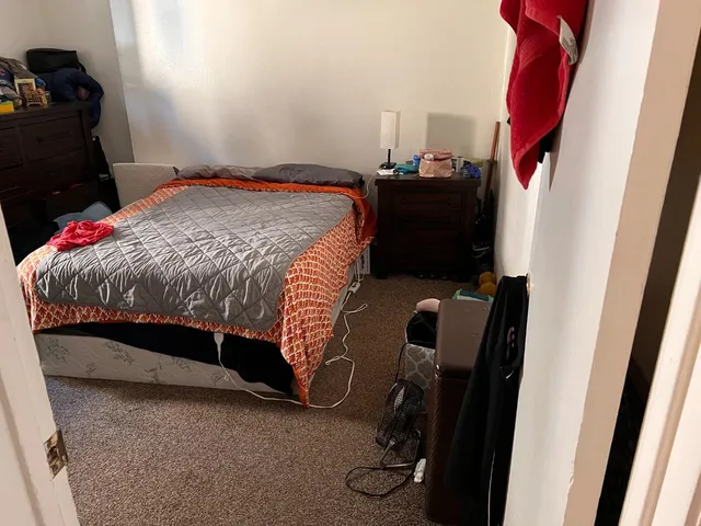 a bed sitting in a bedroom next to a window