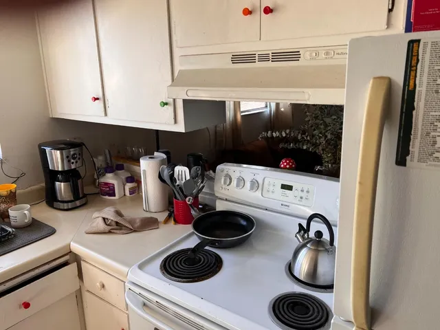 a kitchen with a refrigerator and a stove