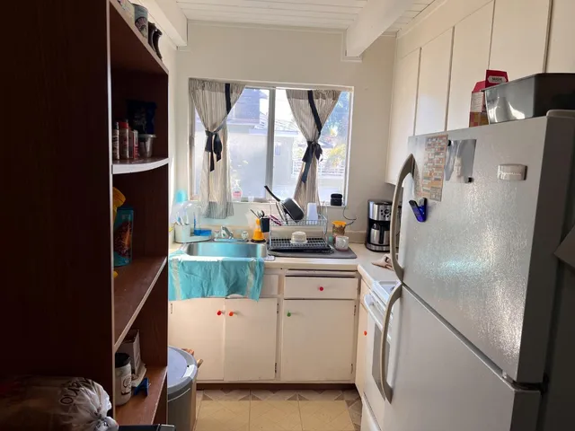 a kitchen with white cabinets and white appliances