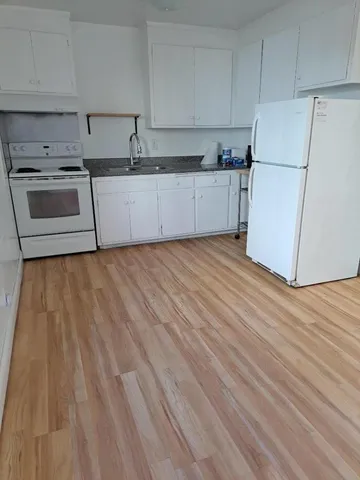 a kitchen with granite countertop a sink stove and refrigerator