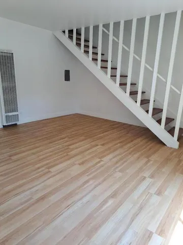 a view of an empty room with wooden floor