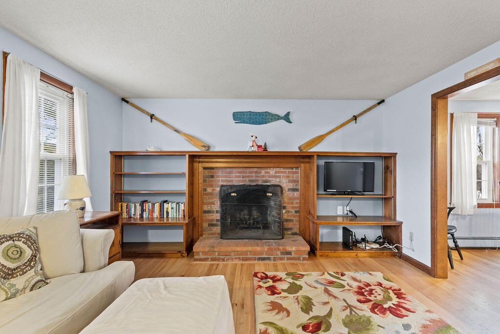 50 Circle Drive Hyannis, MA 02601 - Photo 12 of 32 a living room with furniture a rug and a fireplace