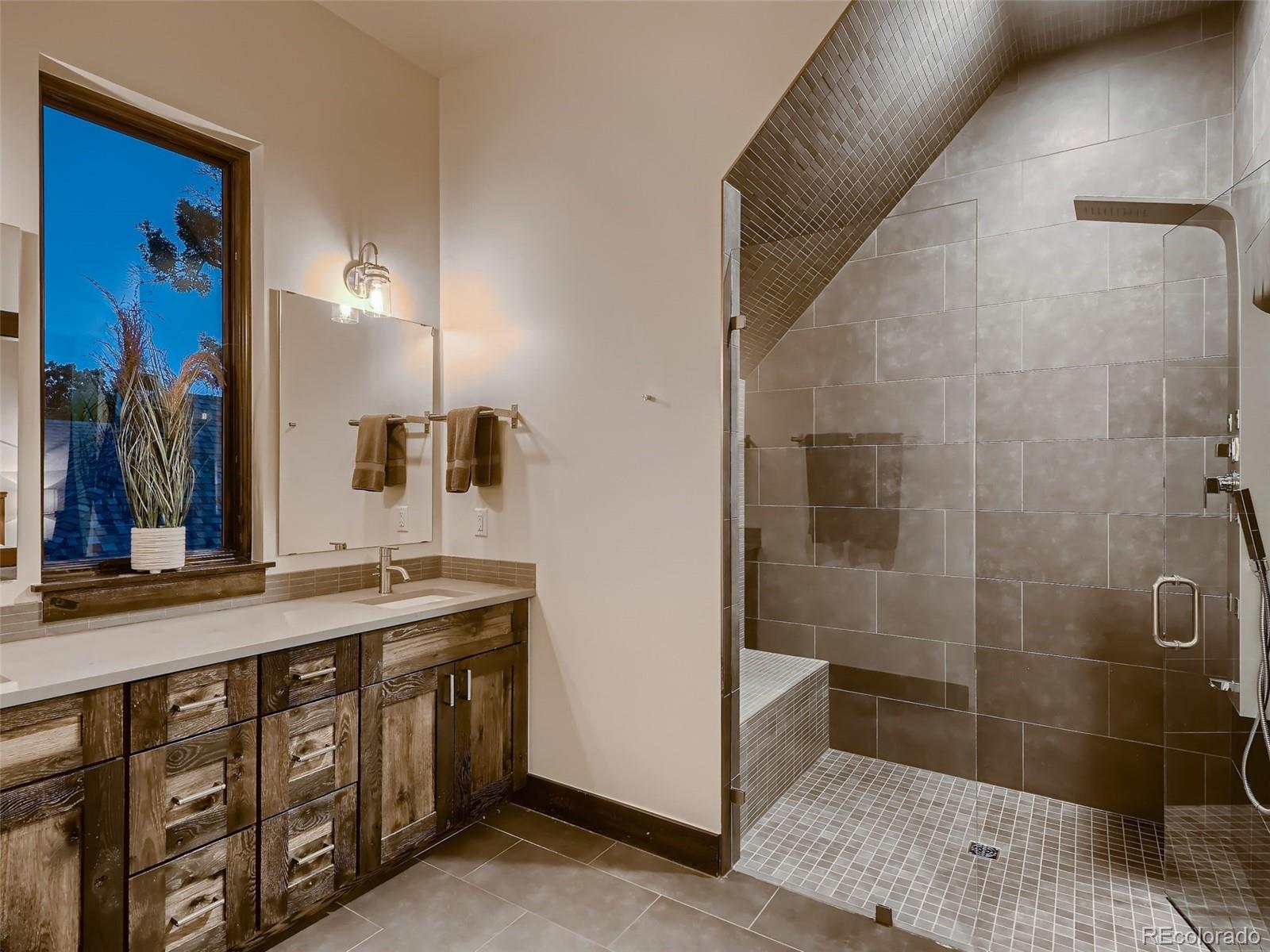 3548 Decatur Street Denver, CO 80211 - Photo 20 of 40 a bathroom with a granite countertop sink a mirror and a shower