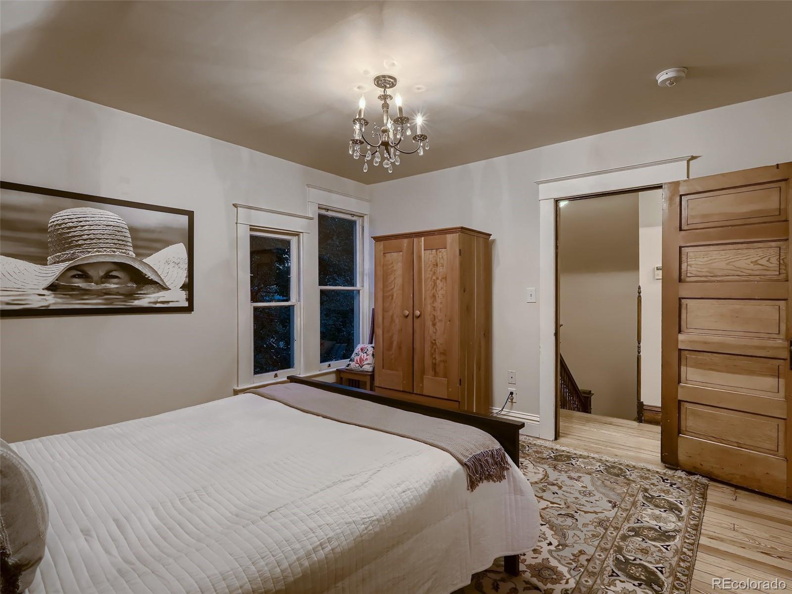 3548 Decatur Street Denver, CO 80211 - Photo 21 of 40 a bedroom with a bed and a chandelier