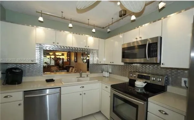 a kitchen with a sink stainless steel appliances and cabinets