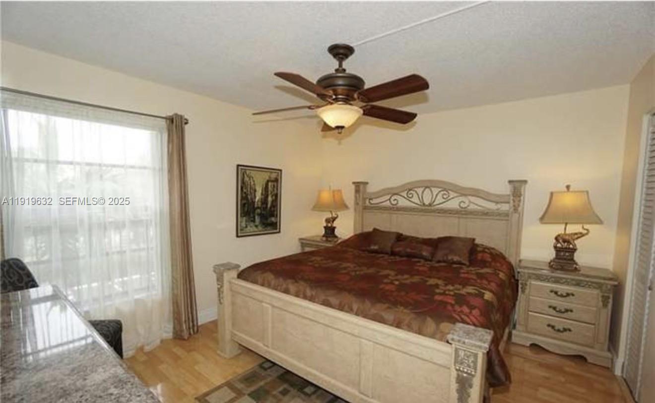 3521 Environ Boulevard, Unit B308 Lauderhill, FL 33319 - Photo 3 of 15 a bedroom with a bed and a chandelier