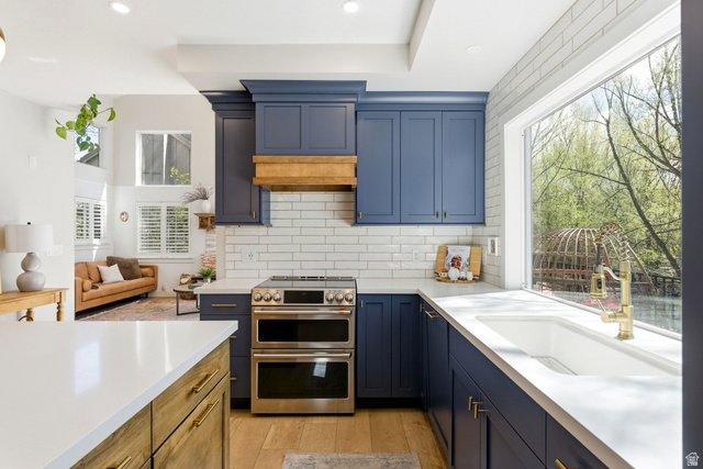 7935 Mustang Loop Road Park City, UT 84098 - Photo 23 of 60 Kitchen featuring navy cabinetry, subway tile backsplash, stainless steel double oven range, white countertop surfaces, and a large window above the sink