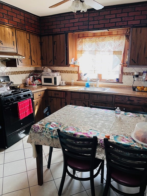 53 Hillside Avenue Everett, MA 02149 - Photo 8 of 11 a kitchen with a stove a sink and a refrigerator