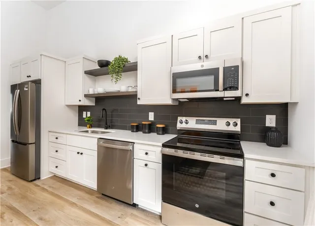 a kitchen with stainless steel appliances granite countertop a stove a sink and a microwave