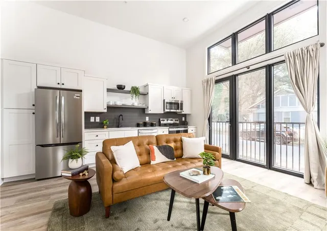 a living room with furniture wooden floor and a large window