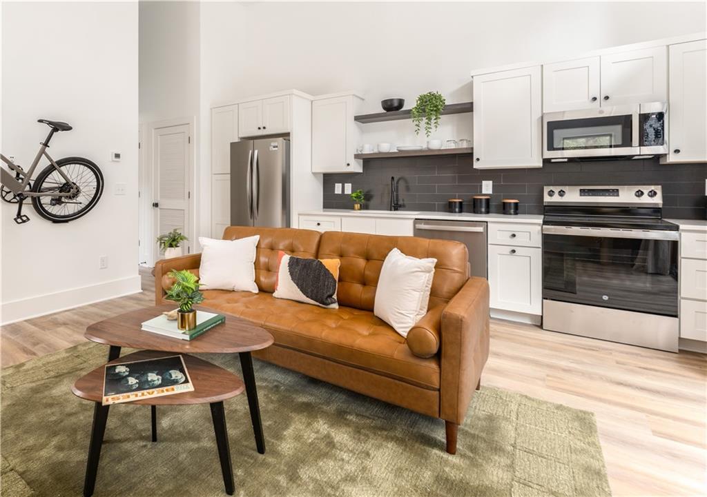 1160 Gracewood Avenue Southeast, Unit 111 Atlanta, GA 30316 - Photo 10 of 38 a living room with stainless steel appliances a stove a kitchen island a stove a dining table and chairs