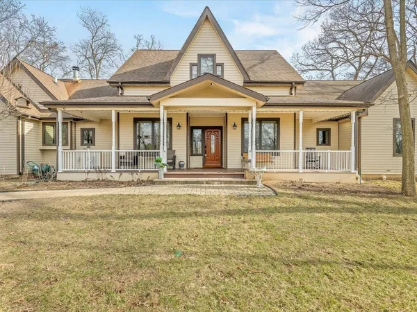 a kitchen with stainless steel appliances granite countertop a refrigerator a sink dishwasher a dining table and chairs with wooden floor