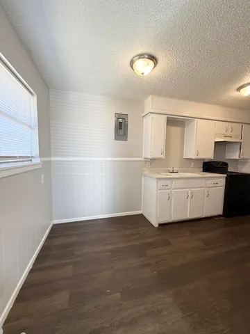 a view of a kitchen with wooden floor and electronic appliances