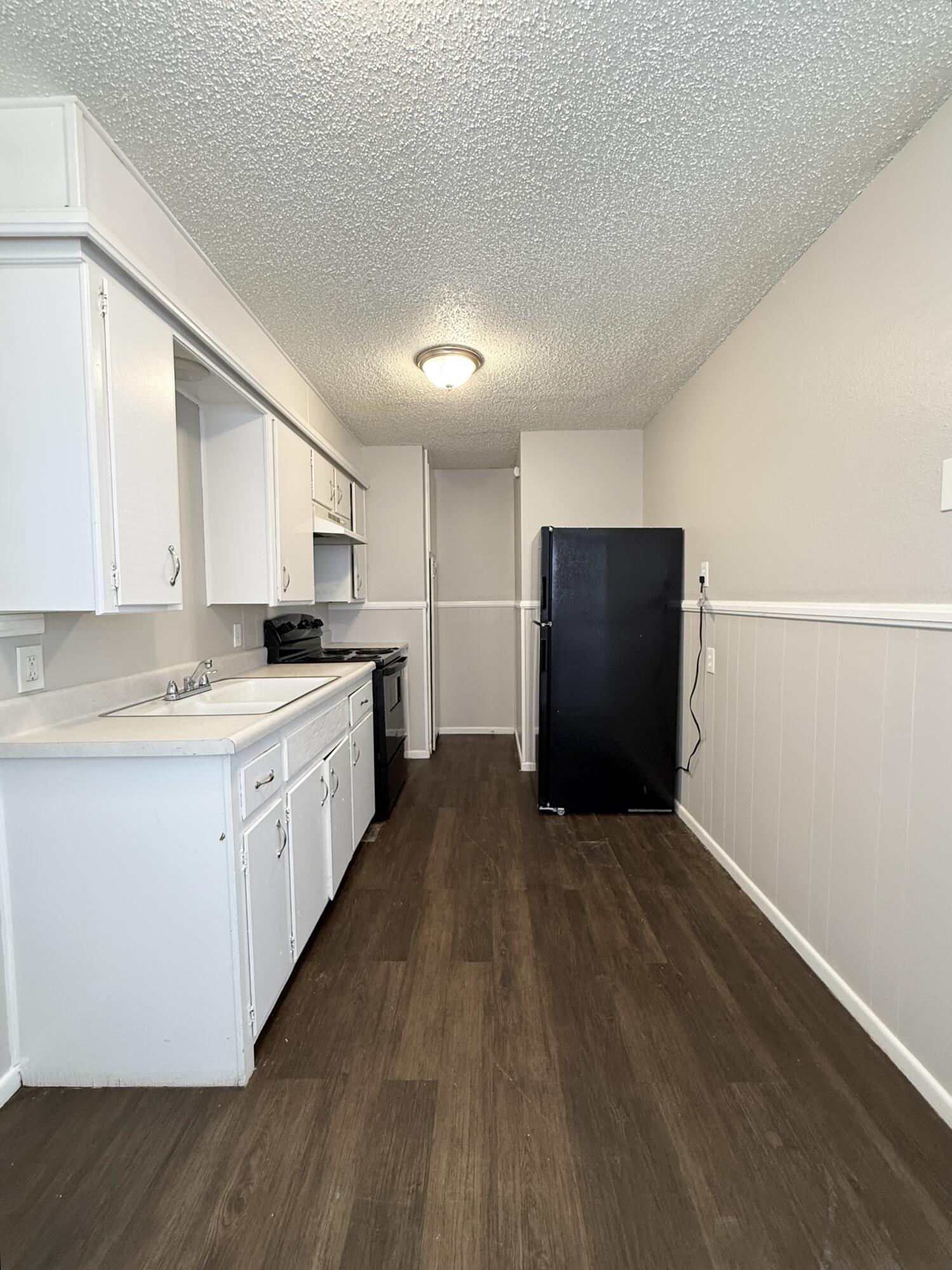 922 44th Street, Unit A Lubbock, TX 79412 - Photo 8 of 16 a kitchen with granite countertop white cabinets and refrigerator