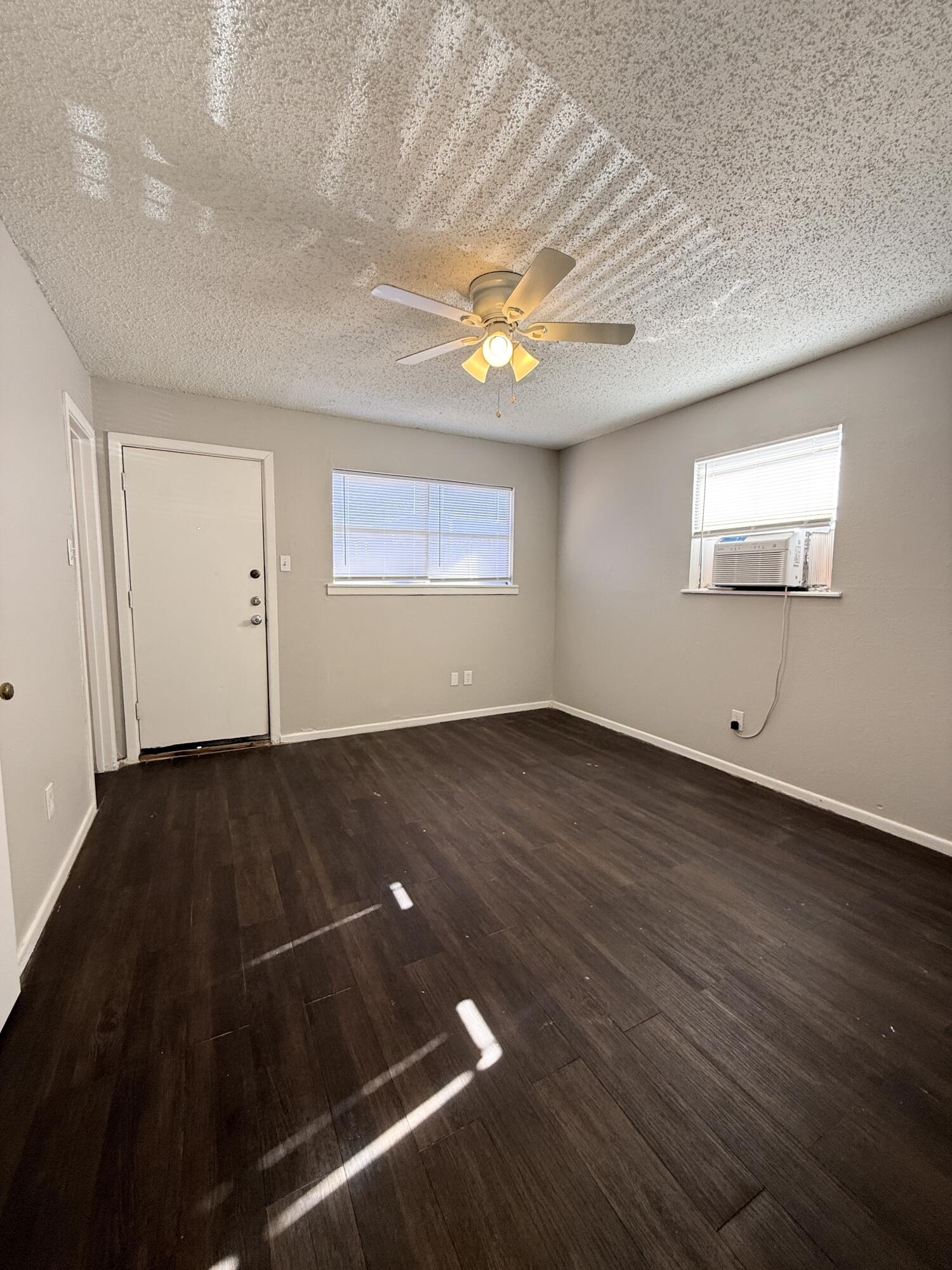 922 44th Street, Unit A Lubbock, TX 79412 - Photo 10 of 16 an empty room with wooden floor and windows
