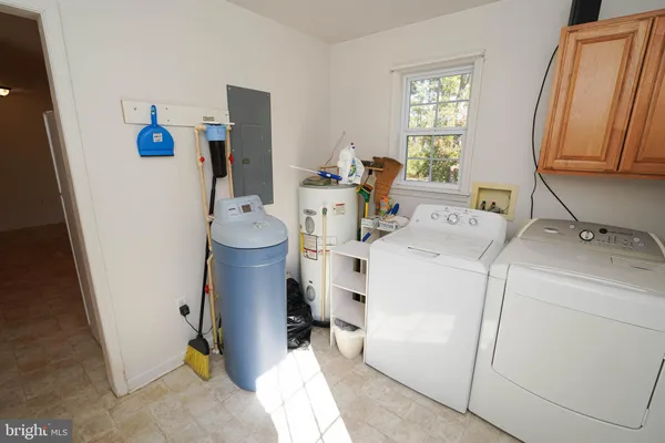 an empty room with wooden floor chandelier fan and windows