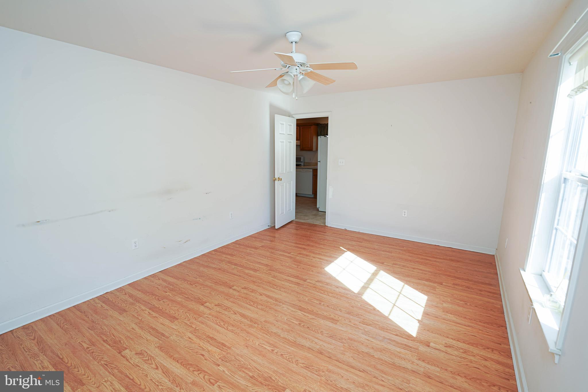 23290 Custom House Road Deal Island, MD 21821 - Photo 19 of 64 an empty room with wooden floor chandelier fan and windows