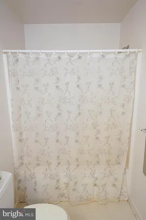 a view of an empty room with furniture and a window