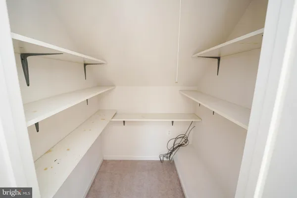 an aerial view of a house with yard and trees in the background