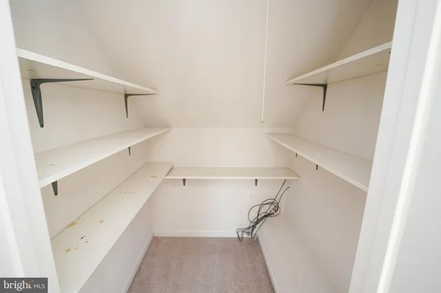 an aerial view of a house with yard and trees in the background