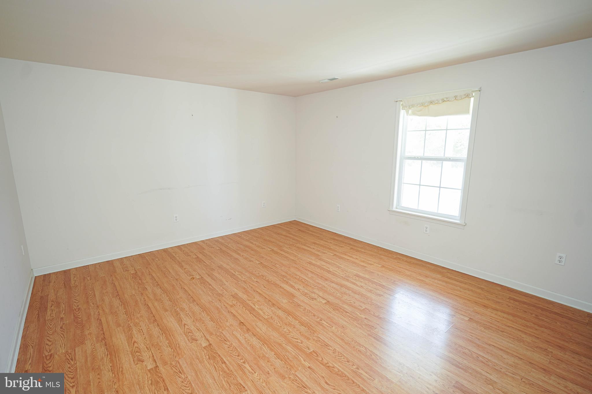 23290 Custom House Road Deal Island, MD 21821 - Photo 7 of 64 an empty room with wooden floor and windows