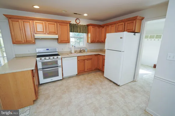 a kitchen with granite countertop a sink stove and cabinets