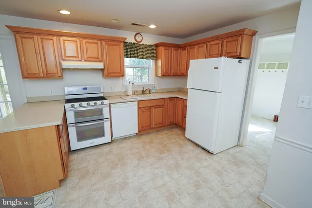 a kitchen with granite countertop a sink stove and cabinets