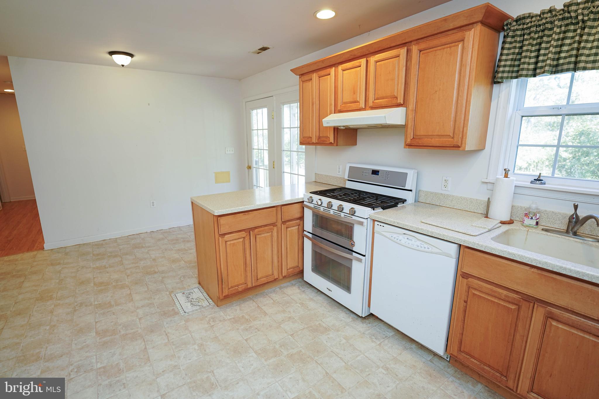 23290 Custom House Road Deal Island, MD 21821 - Photo 9 of 64 a kitchen with granite countertop a sink stove and cabinets