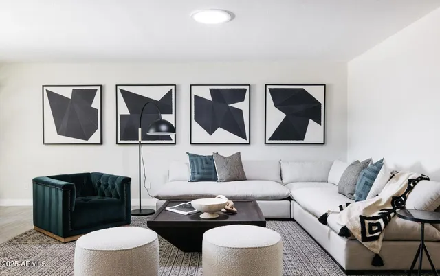 a living room with furniture and a painting on the wall