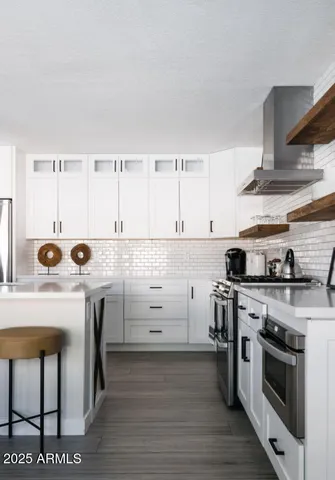 a kitchen with cabinets wooden floor and stainless steel appliances