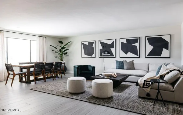 a living room with furniture kitchen view and a window