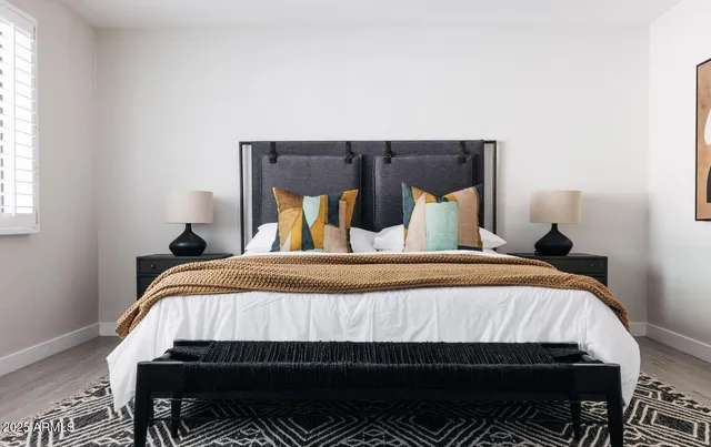 a bedroom with a bed and wooden floor