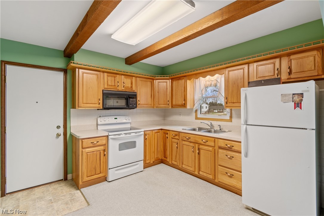 41 Willard Street Rittman, OH 44270 - Photo 8 of 25 Kitchen with white appliances, beam ceiling, and sink
