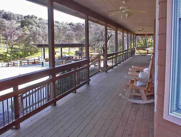a view of a patio with dining table and chairs with wooden floor and fence