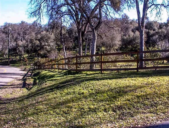 a view of a yard with wooden fence