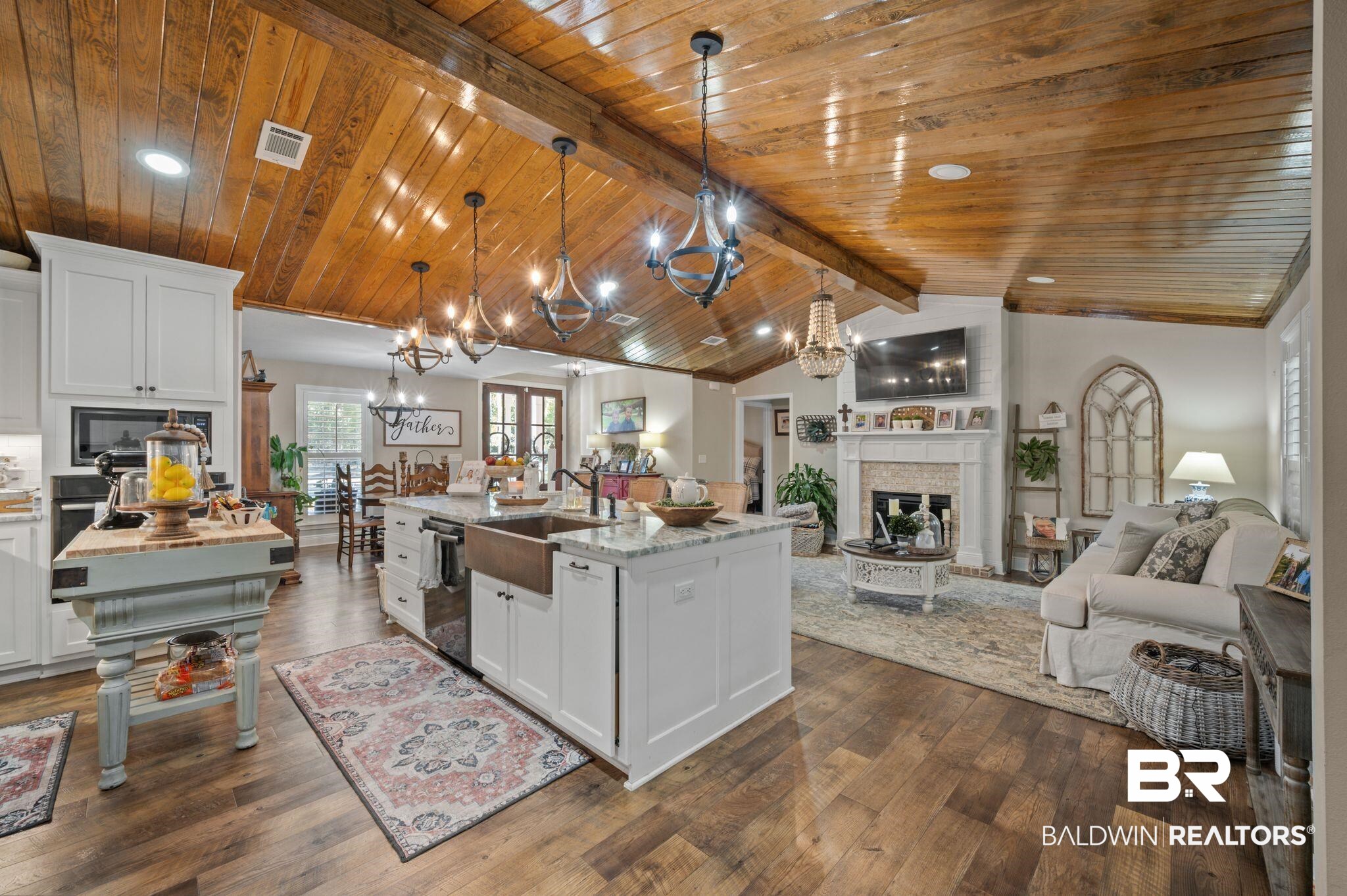 38211-d) V R Byrd Road Bay Minette, AL 36507 - Photo 7 of 58 Kitchen featuring dark hardwood / wood-style flooring, lofted ceiling with beams, decorative light fixtures, a center island with sink, and white cabinets