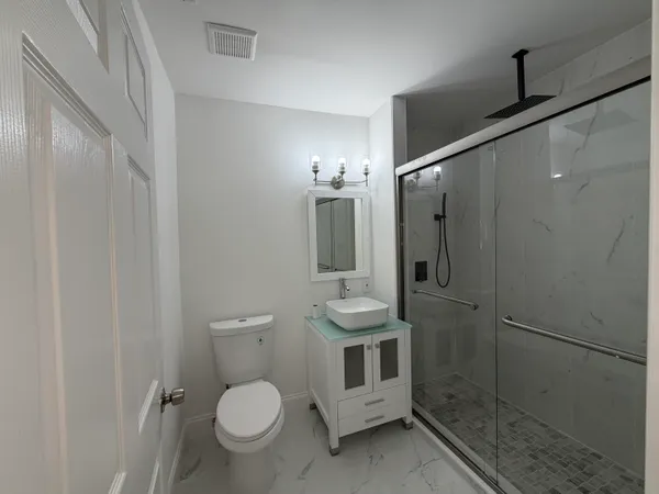 a bathroom with a toilet a sink and shower